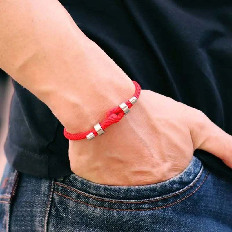 Red adjustable cord bracelet worn on the wrist