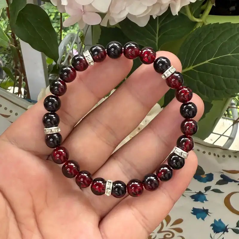 Haven Crackle Glass Bead Bracelet held in hand, deep red bead detail