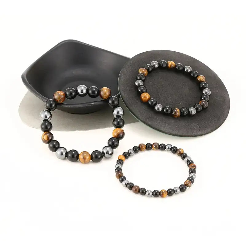 Three Triad Protection bracelets stacked together showing bead size range