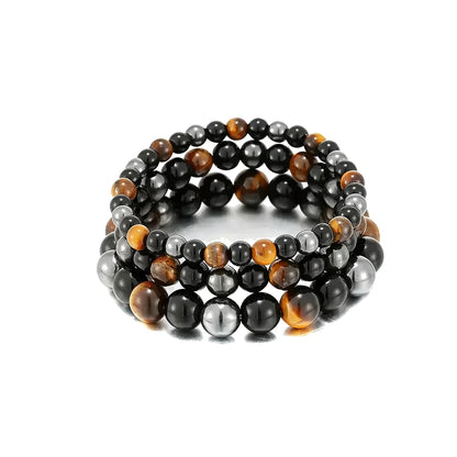 Three stacked bead bracelets combining tiger eye, black obsidian, and hematite beads, on a white background.