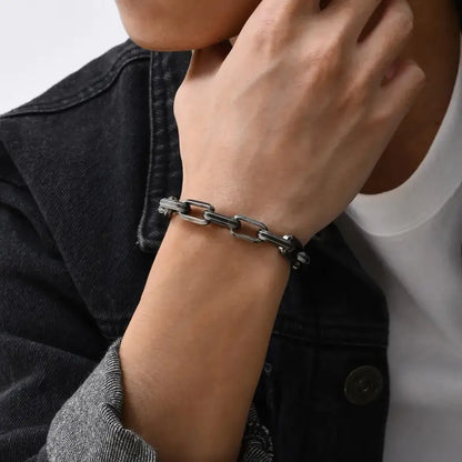Man wearing an oxidized paperclip chain bracelet on his wrist with a denim jacket