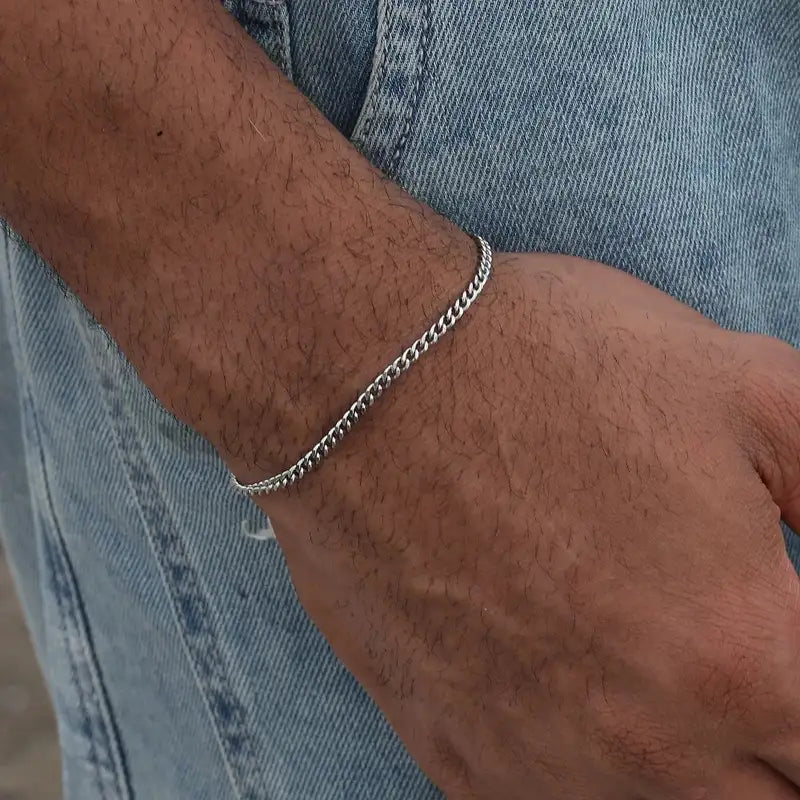 Silver Cuban curb chain bracelet worn on the wrist