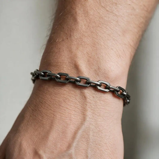 Dark oxidized stainless steel oval cable-link box chain bracelet worn on the wrist