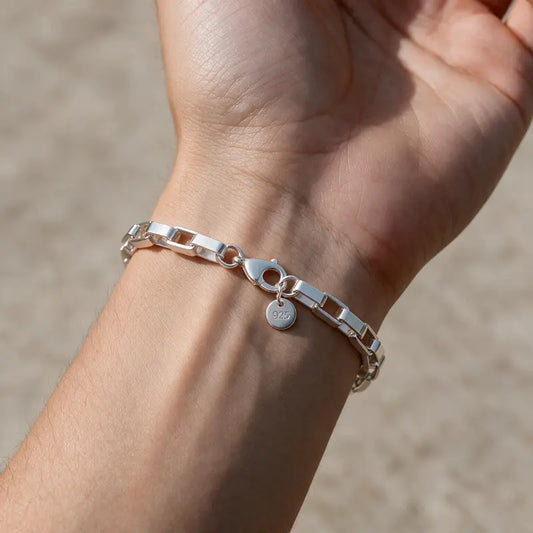 Silver rectangular box-link chain bracelet worn on the wrist