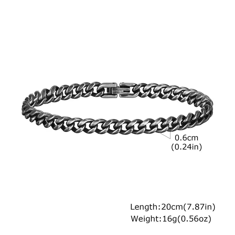6mm oxidized gunmetal stainless steel Cuban curb link bracelet, 20cm, coiled flat on a white background