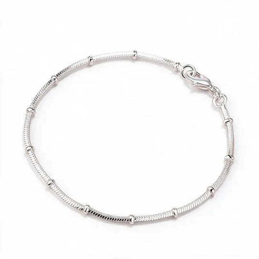 925 sterling silver thin snake chain bracelet with polished bead stations, product photo on white background