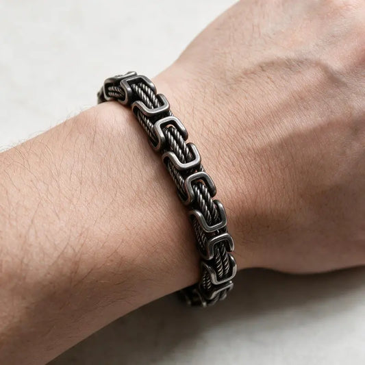 Dark oxidized stainless steel Byzantine bracelet with twisted cable links worn on the wrist