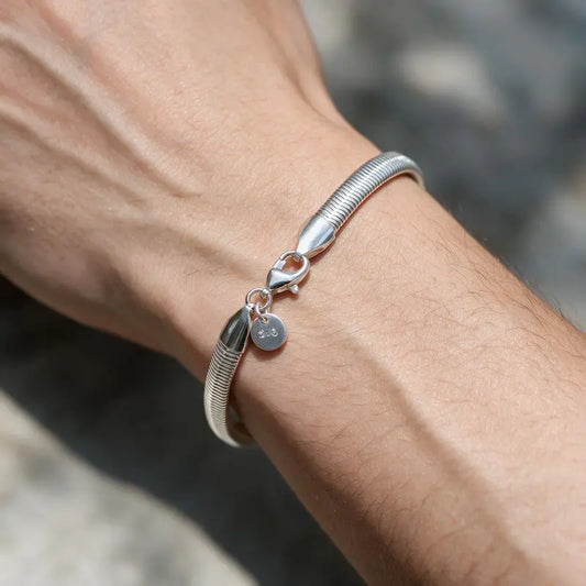 Smooth round silver snake chain bracelet worn on the wrist