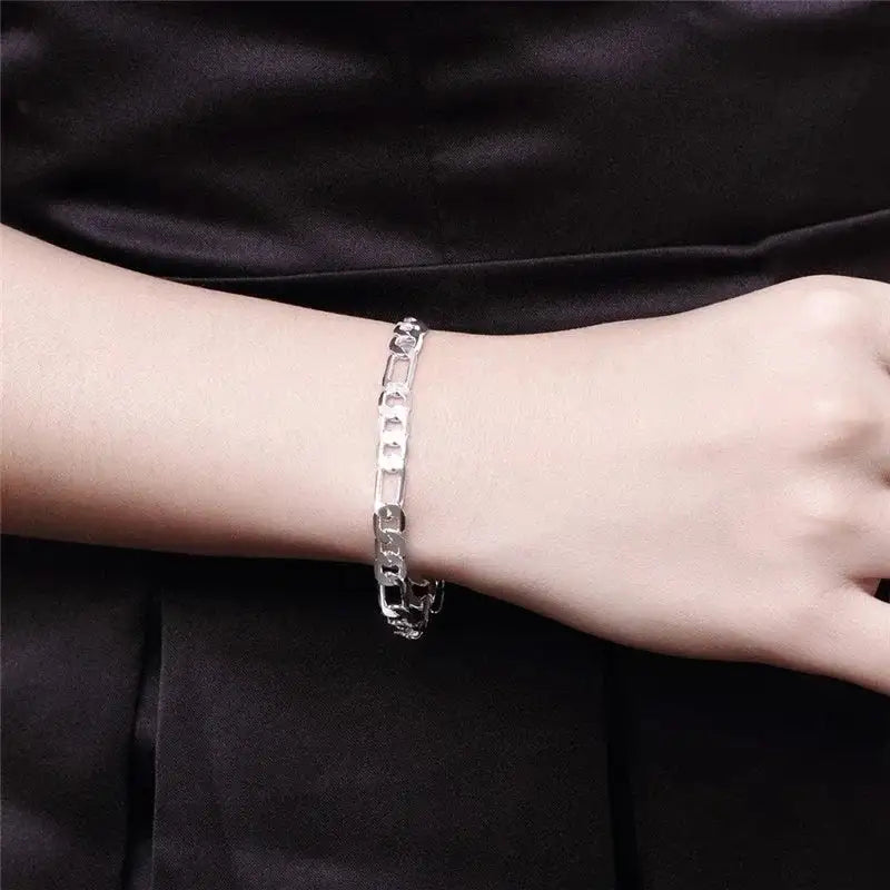 Silver figaro chain bracelet worn on the wrist