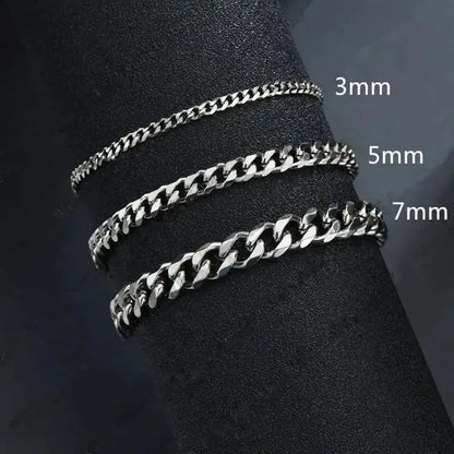 Silver Cuban link chains in 3mm, 5mm and 7mm widths compared on a dark display stand