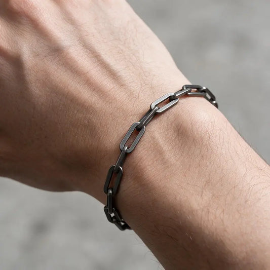 Thin dark oxidized stainless steel paperclip link chain bracelet worn on the wrist