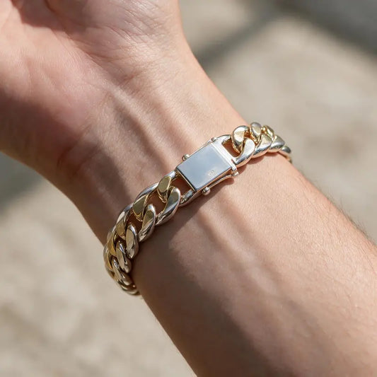 Two-tone gold and silver Cuban curb chain bracelet worn on the wrist