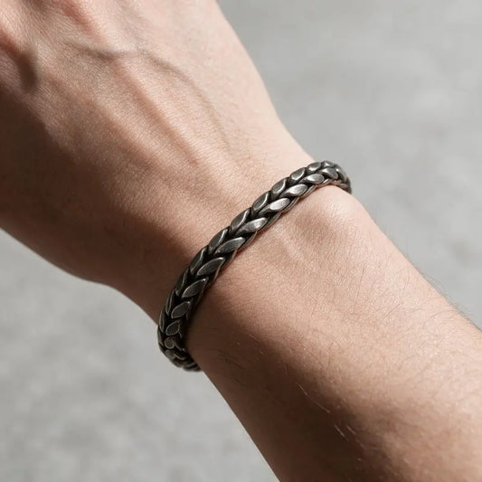 Dark oxidized stainless steel wheat link bracelet worn on the wrist
