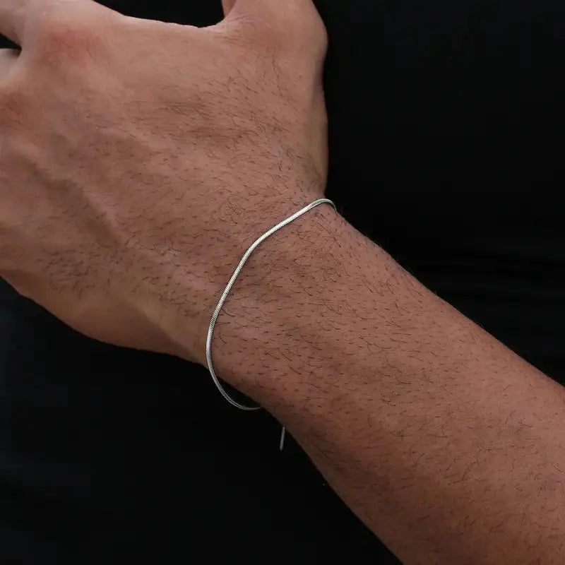 Silver snake chain bracelet worn on the wrist, close-up