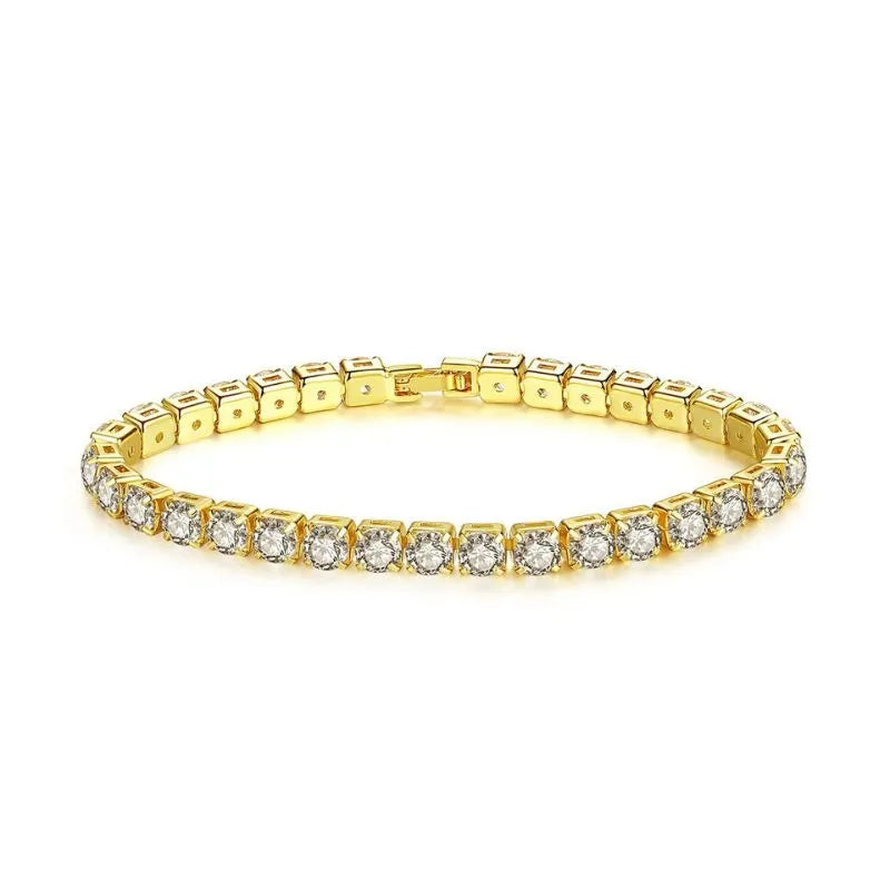 Gold tennis bracelet with round cubic zirconia stones laid flat in an oval on a plain white background.
