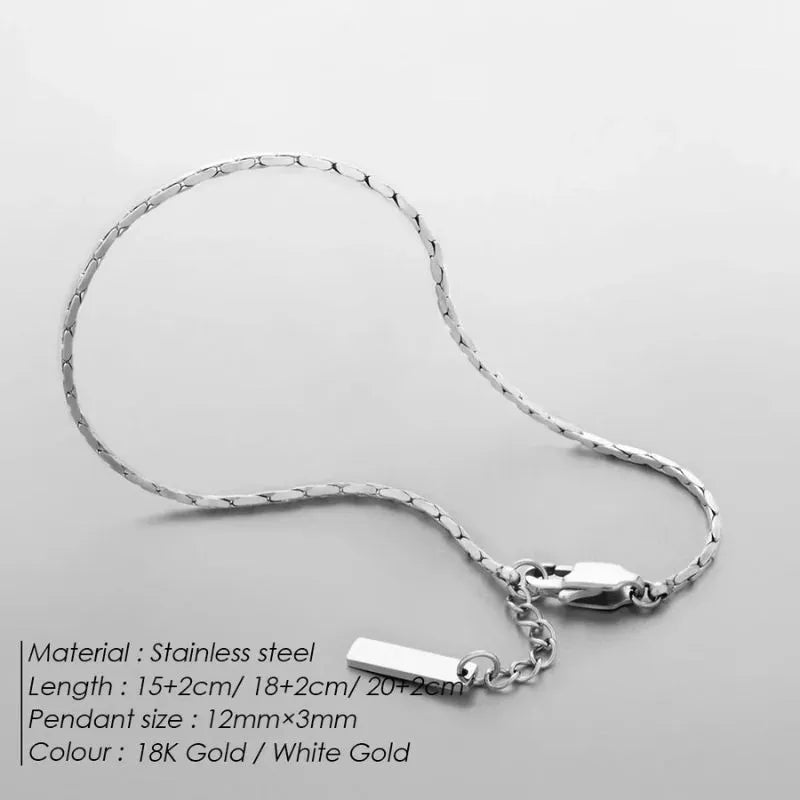 Silver-tone wire chain bracelet laid in a loose curve on a light grey background, labeled with material, length options, and color details.