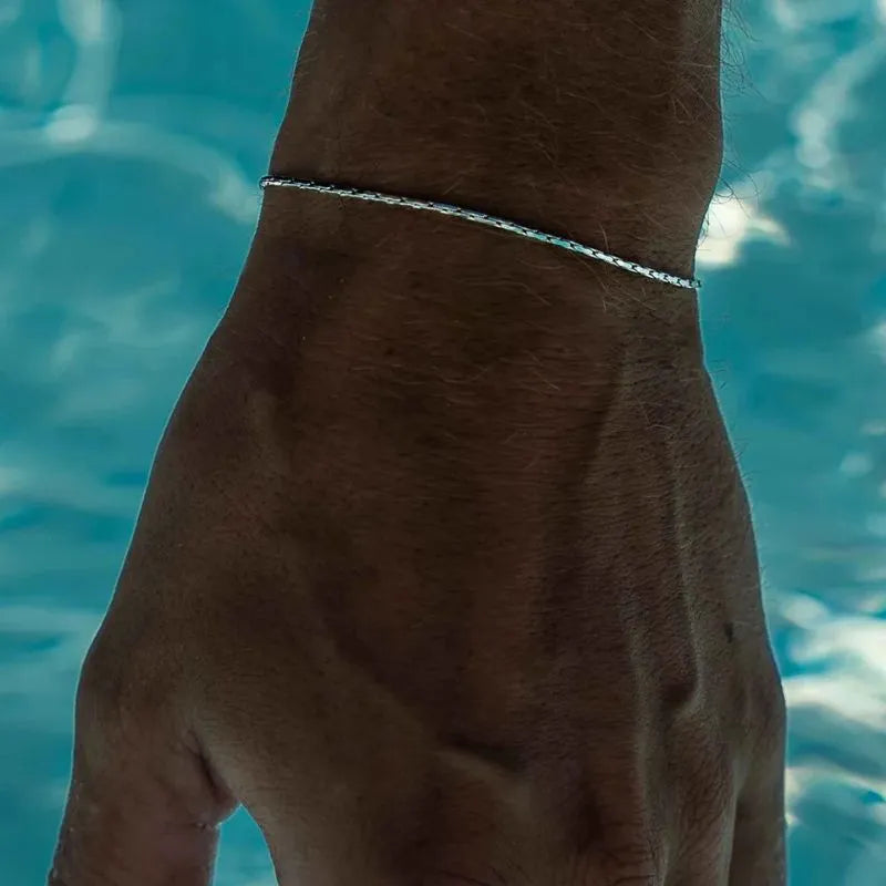 Elegant stainless steel wire bracelet with a polished gold finish for modern masculine fashion.