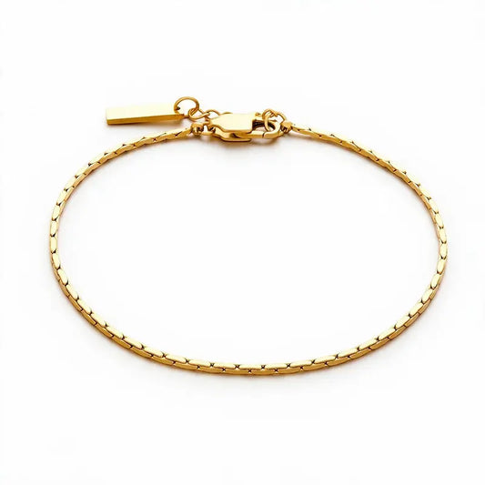 Gold ultra-thin wire chain bracelet with a rectangular bar tag charm, on a plain white background.