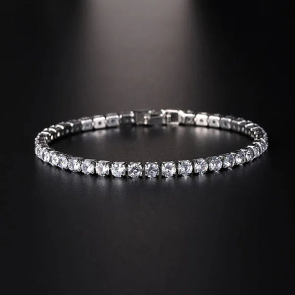 Silver tennis bracelet with clear cubic zirconia stones under a dramatic spotlight on a black background