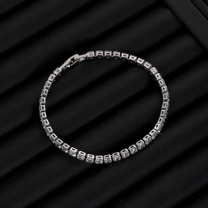 Silver tennis bracelet with clear stones laid in a circle on a black ribbed jewellery tray