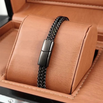 Black wheat link chain bracelet with a matching clasp, displayed on a tan leather jewellery stand