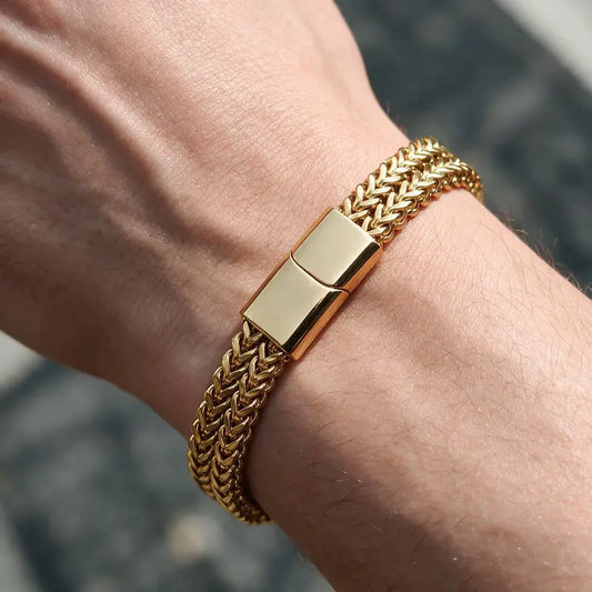 Gold wheat link chain bracelet worn on a man's wrist.
