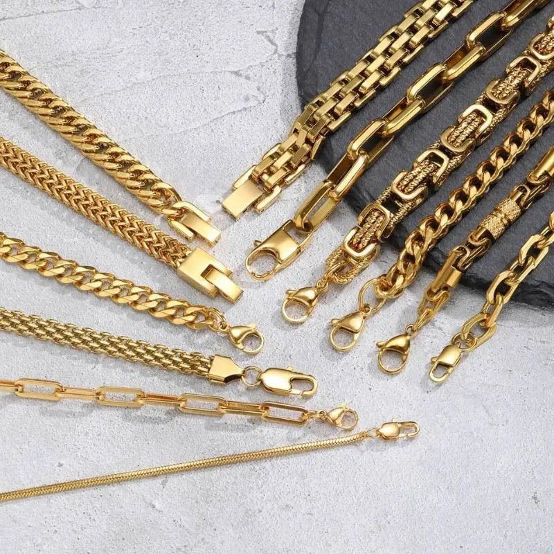 Close-up spread of gold chain bracelets on a stone slab showing each style's lobster clasp in detail