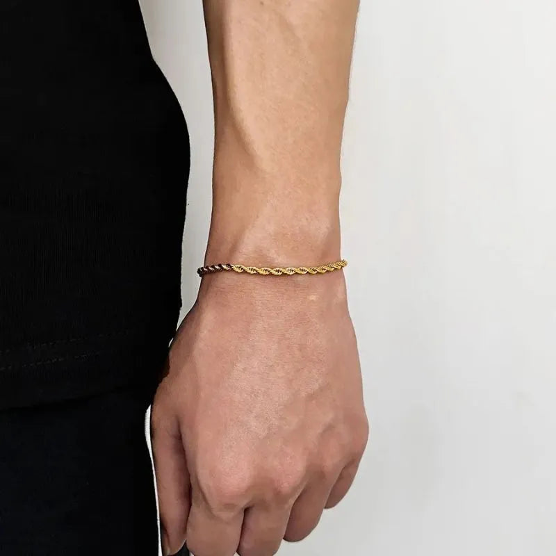 Gold twisted Singapore rope chain bracelet worn on the wrist, side profile against a white background.