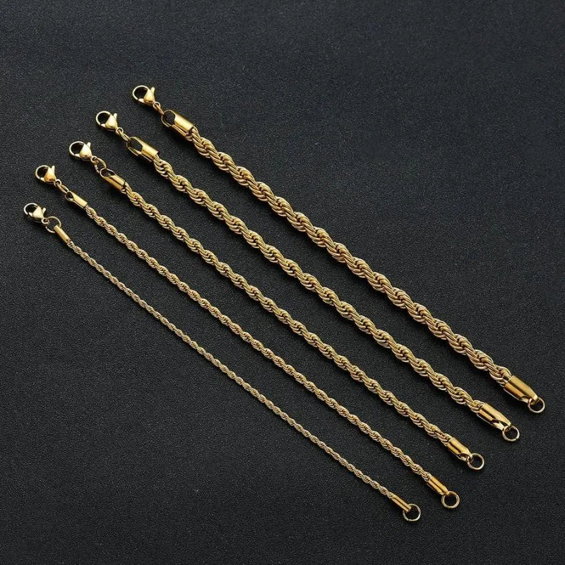 Five gold twisted rope chain bracelets of increasing width laid diagonally over a black display stand.