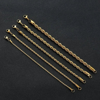 Five gold twisted rope chain bracelets of increasing width laid diagonally over a black display stand.