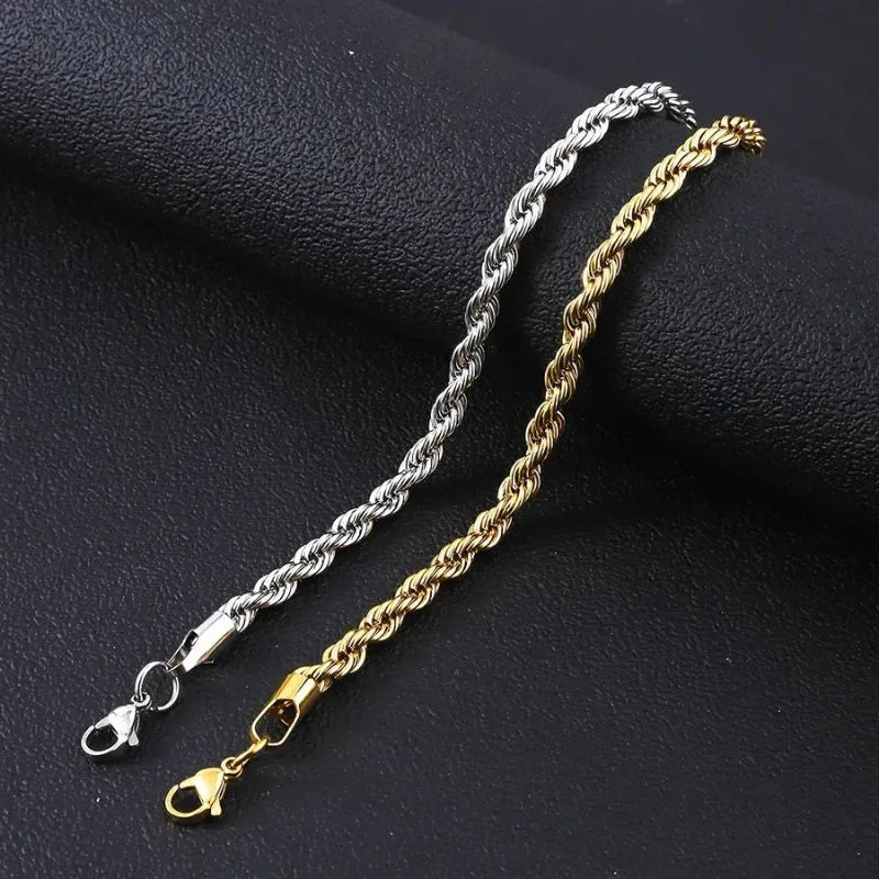 Silver and gold twisted rope chain bracelets draped side by side over a black textured surface, comparing the two colors.