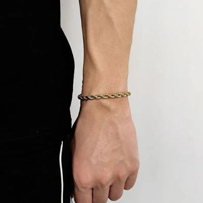 Two-tone dark and silver twisted rope chain bracelet worn on the wrist, side profile against a white background.