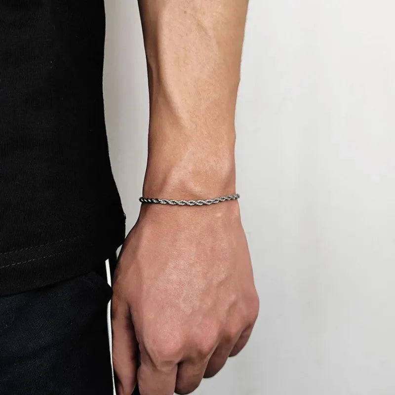 Silver-tone twisted rope chain bracelet worn on the wrist, side profile against a white background.