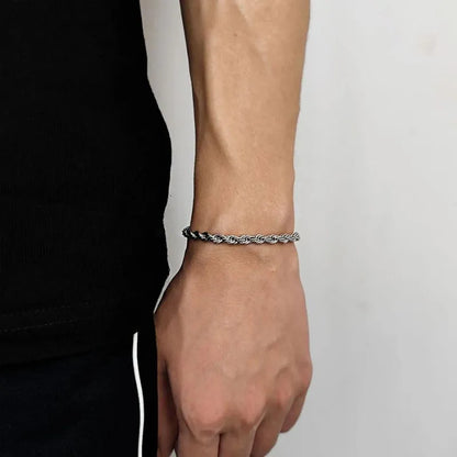 Thicker silver-tone twisted rope chain bracelet worn on the wrist, side profile against a white background.