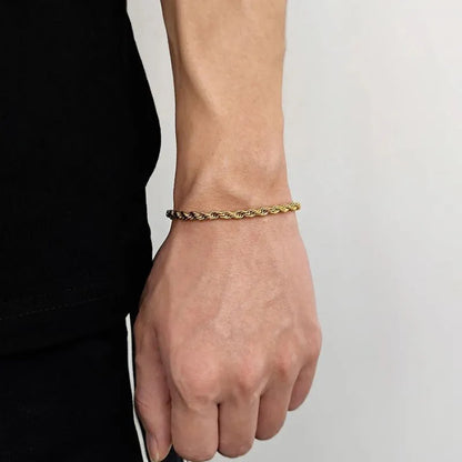 Thicker gold twisted rope chain bracelet worn on the wrist, side profile against a white background.