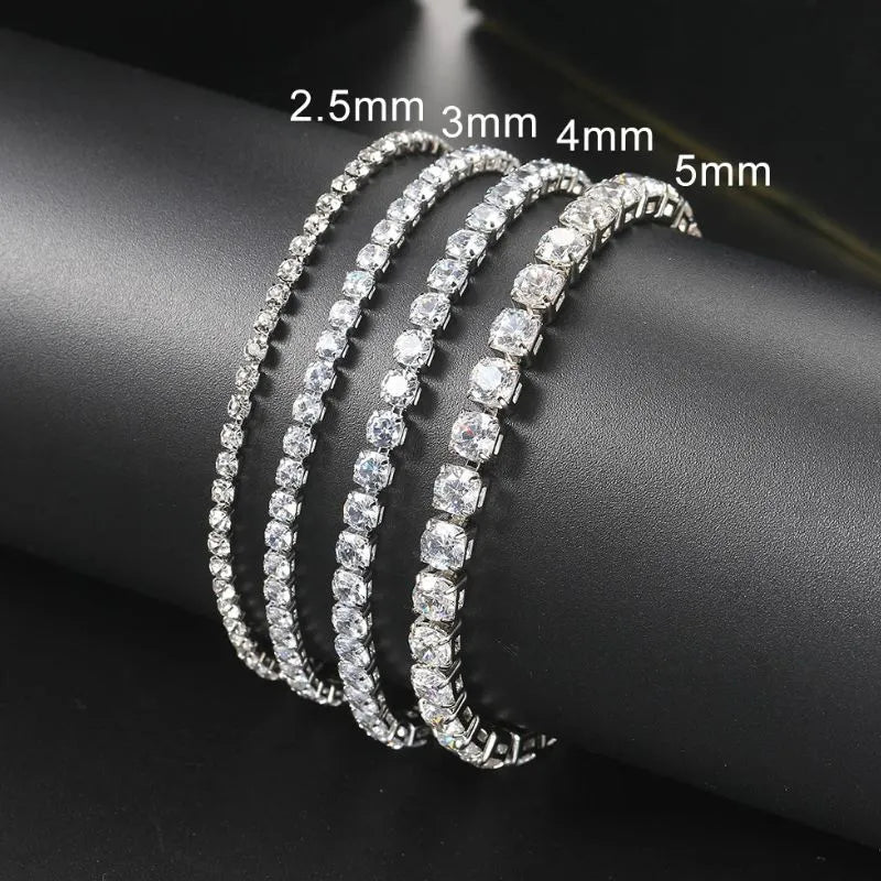 Four silver tennis bracelets in increasing stone sizes — 2.5mm, 3mm, 4mm, and 5mm — draped around a black display stand.