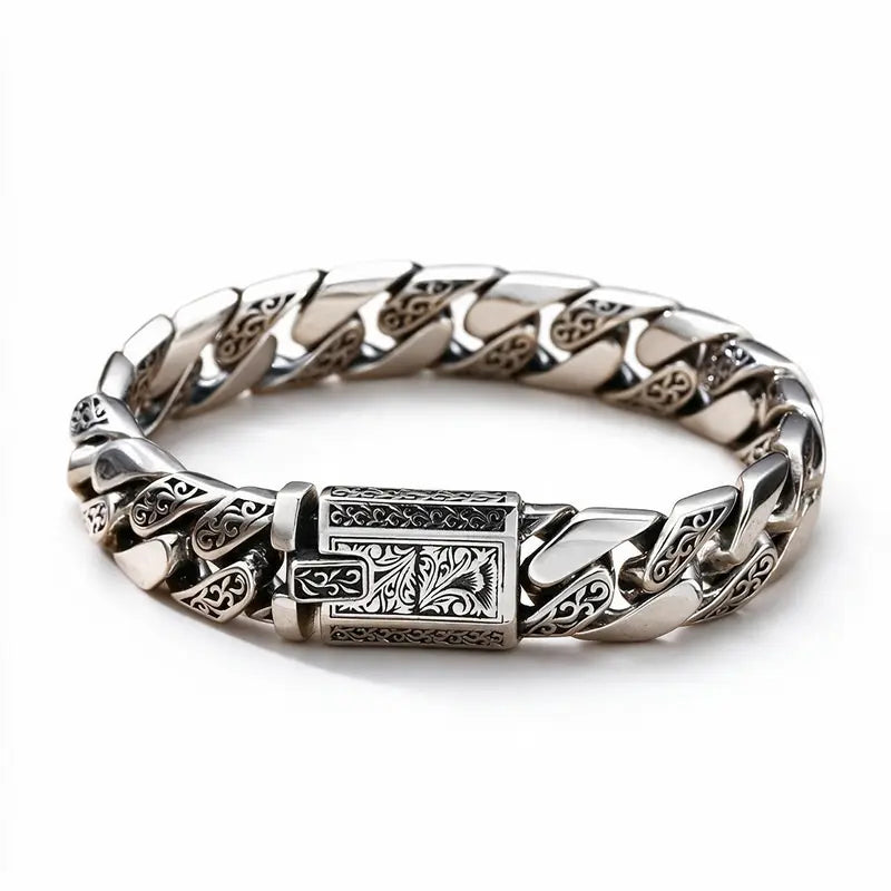 Engraved silver Cuban-link bracelet with an ornate rectangular clasp, on a plain white background.