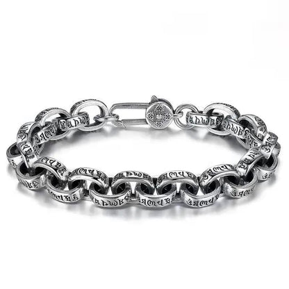 Silver oval-link chain bracelet with engraved Tibetan mantra script on each link, laid in an oval on a plain white background, with a round decorative clasp.