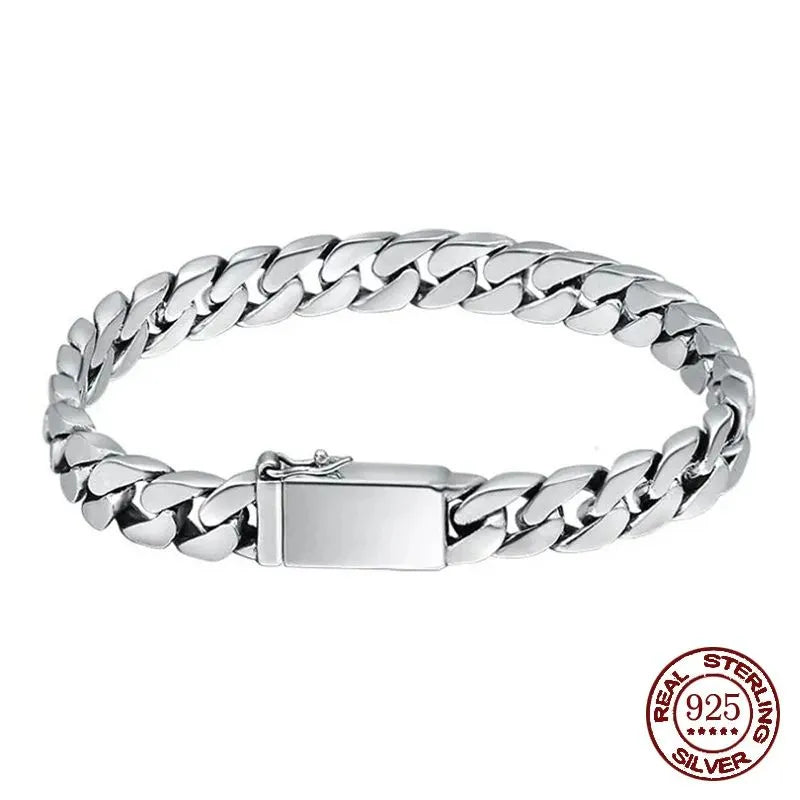 Silver Cuban-link bracelet laid in an oval on a plain white background, with a red 'Real Sterling Silver 925' hallmark stamp in the corner.