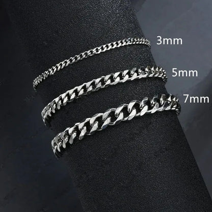 Three silver Cuban chains in 3mm, 5mm, and 7mm widths draped around a black display stand, labeled by width.