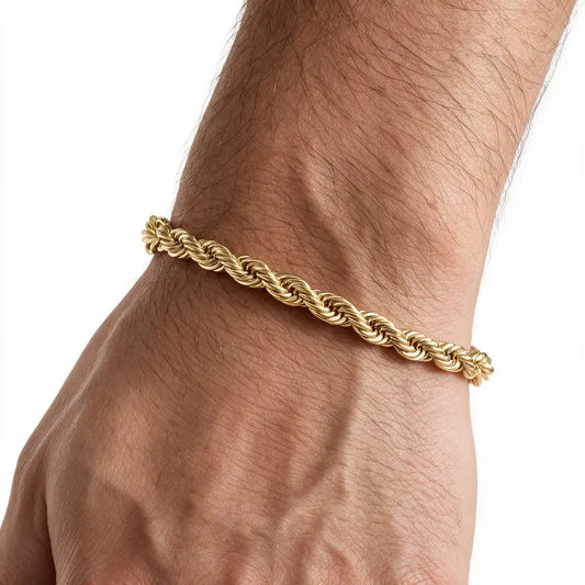 Gold stainless steel twisted rope chain bracelet worn on wrist, white background