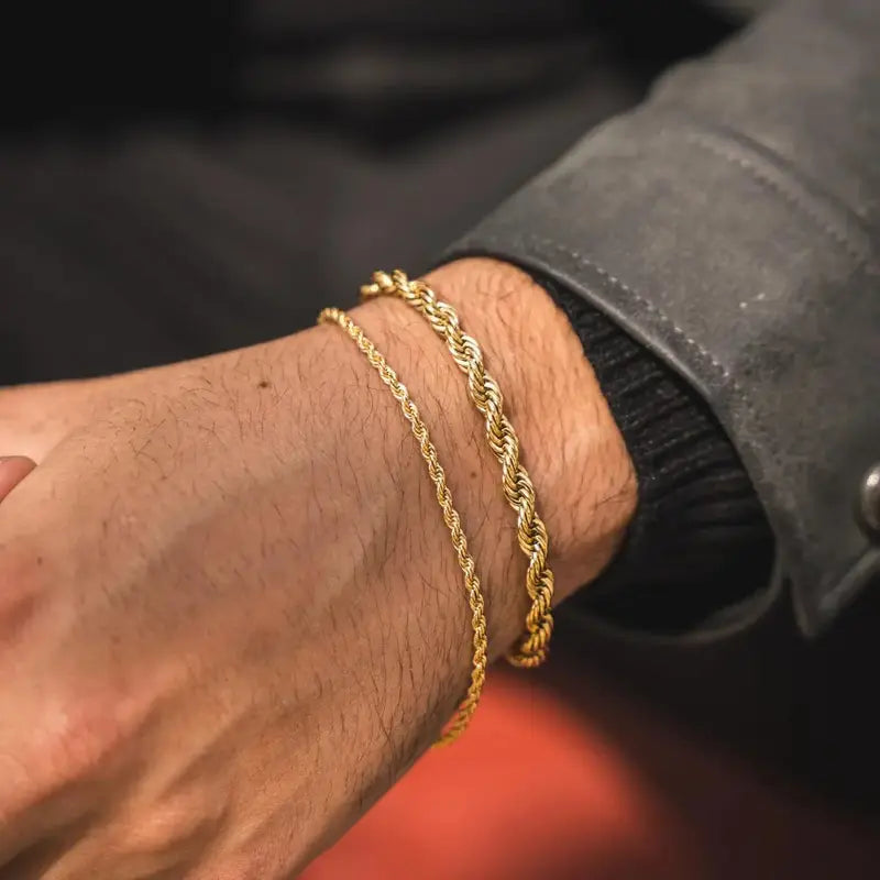 Two gold twisted rope chain bracelets stacked on wrist