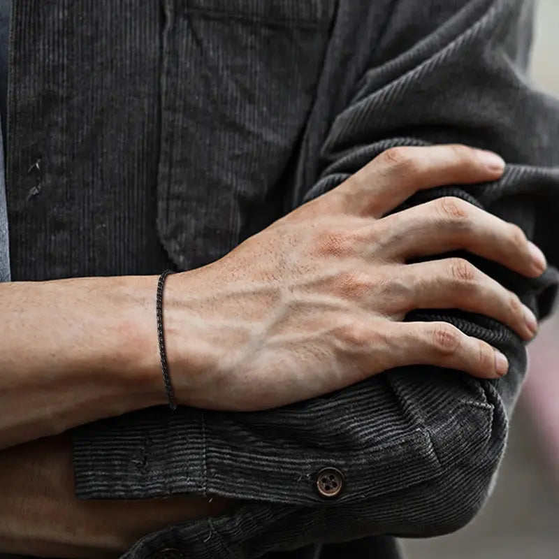 Black stainless steel slim snake link bracelet worn on wrist