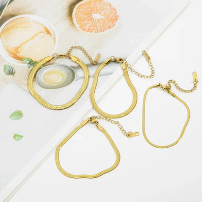 Gold and silver snake chain bracelets on wrist lifestyle shot