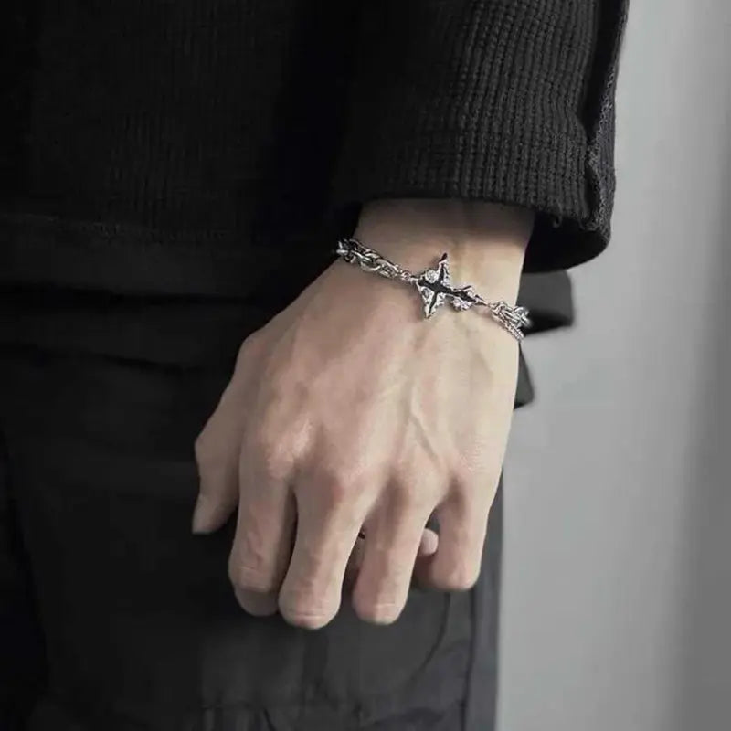 Close-up of gothic cross charm bracelet worn on wrist