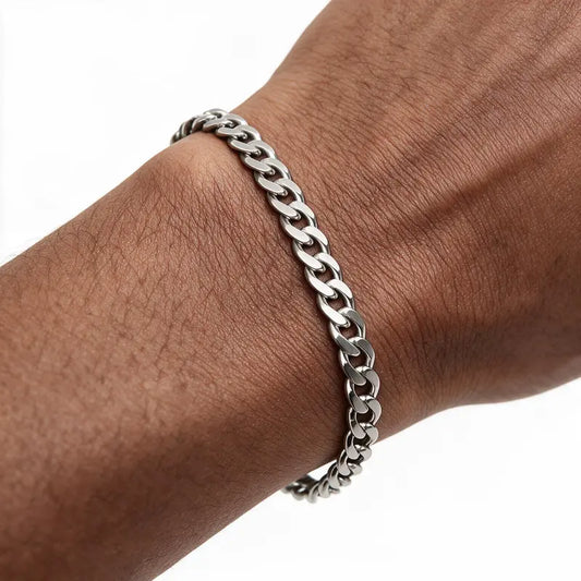 Silver stainless steel curb chain bracelet worn on wrist, white background