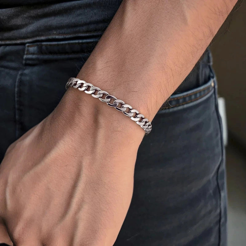 Silver stainless steel curb chain bracelet on wrist with beach shells
