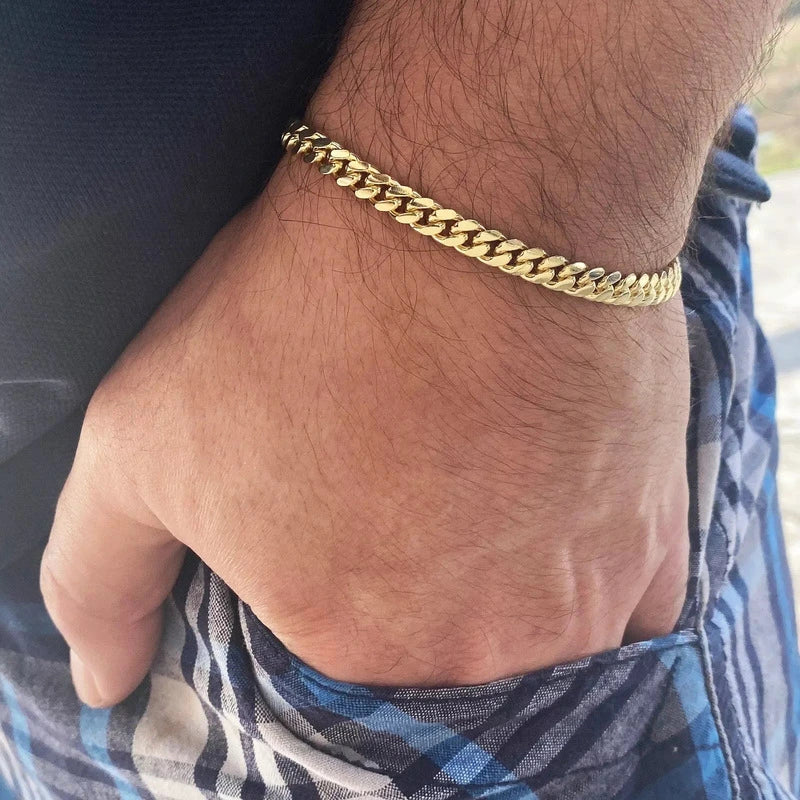 Gold stainless steel curb chain bracelet worn on wrist