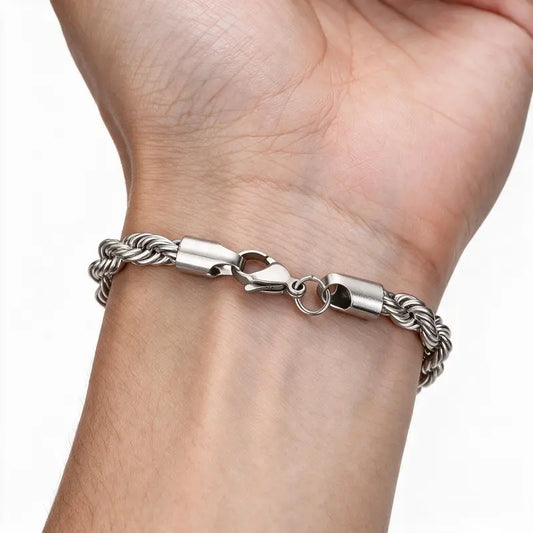 Silver stainless steel twisted rope chain bracelet worn on wrist, white background